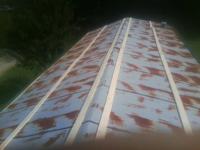 Rusted metal roof panels with new wood purlins before replacement — Storm Damage Roof Repair in Painesville by Roofing Brothers