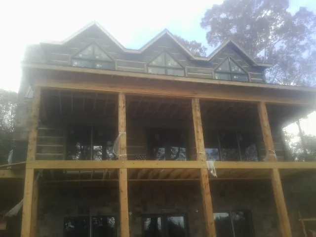 Dormers and porch framing on a large log home under construction — Roof Coating work by our crew in Painesville