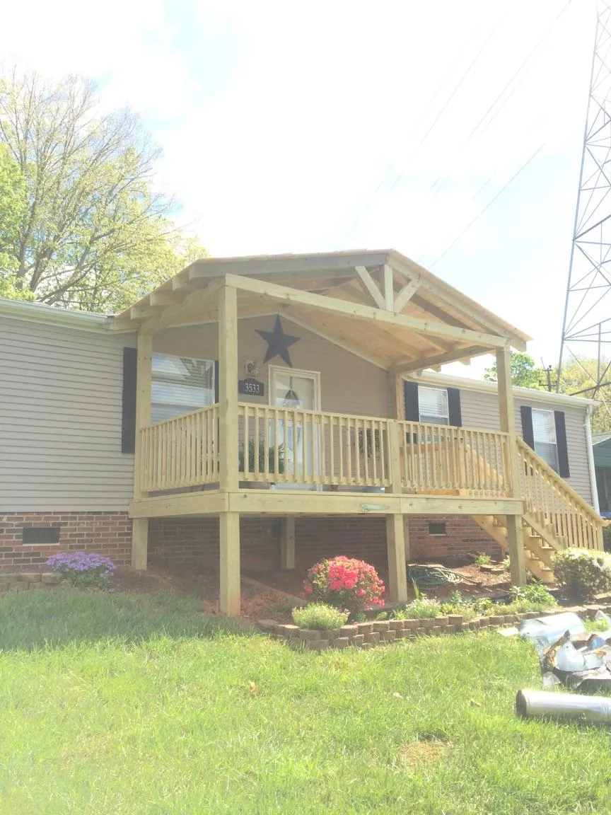 New gabled porch roof and deck railing added to a ranch home in Painesville